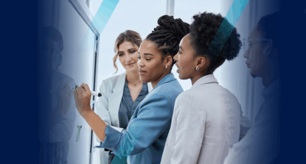 Female HR managers brainstorming SMART goals for HR on whiteboard in boardroom